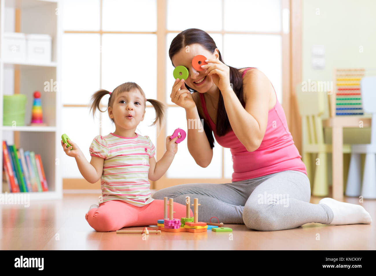 Mother and daughter play on floor having a fun pastime Stock Photo
