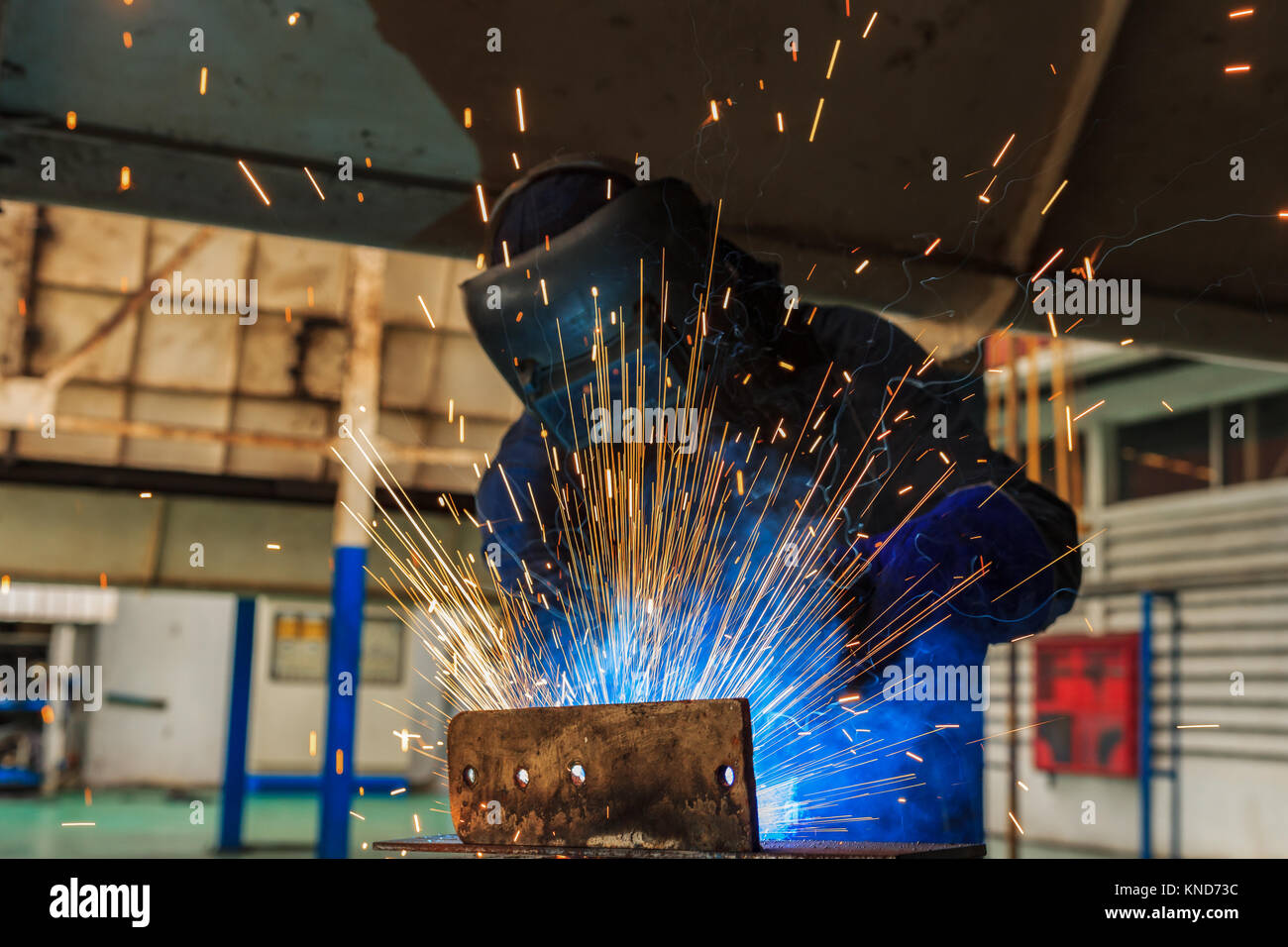 Welder is welding automotive part. Stock Photo