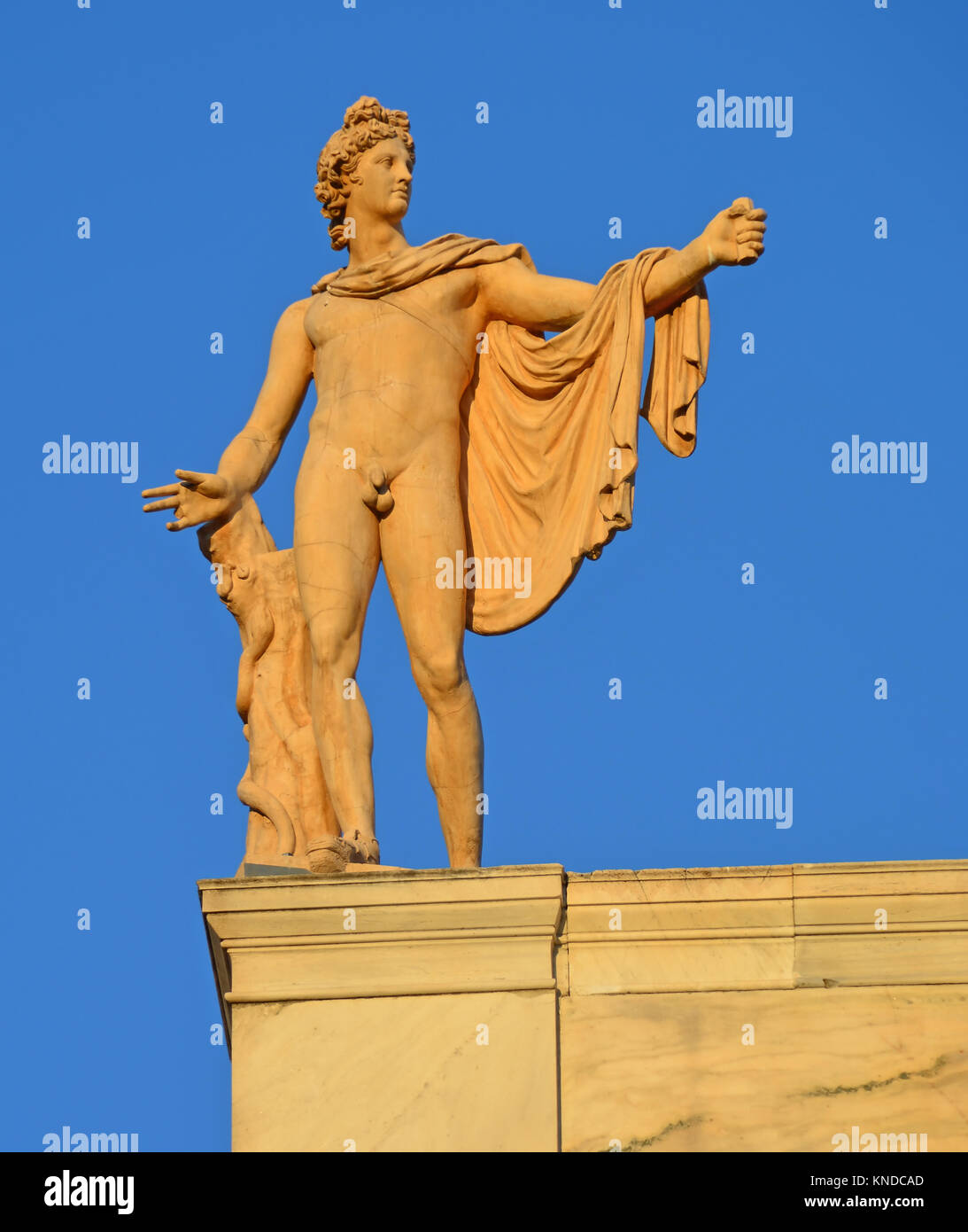 Greek God of the Sun Apollo also god of music, truth and prophesy, with python on a tree trunk. Ancient greek statue by Leochares Stock Photo