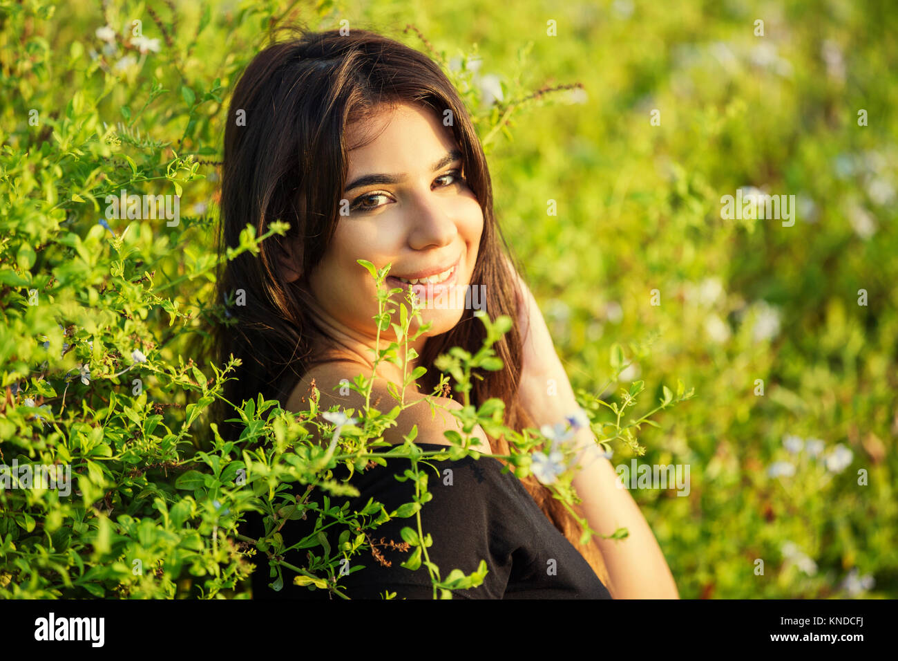 Beautiful young woman standing near the hedge Stock Photo - Alamy