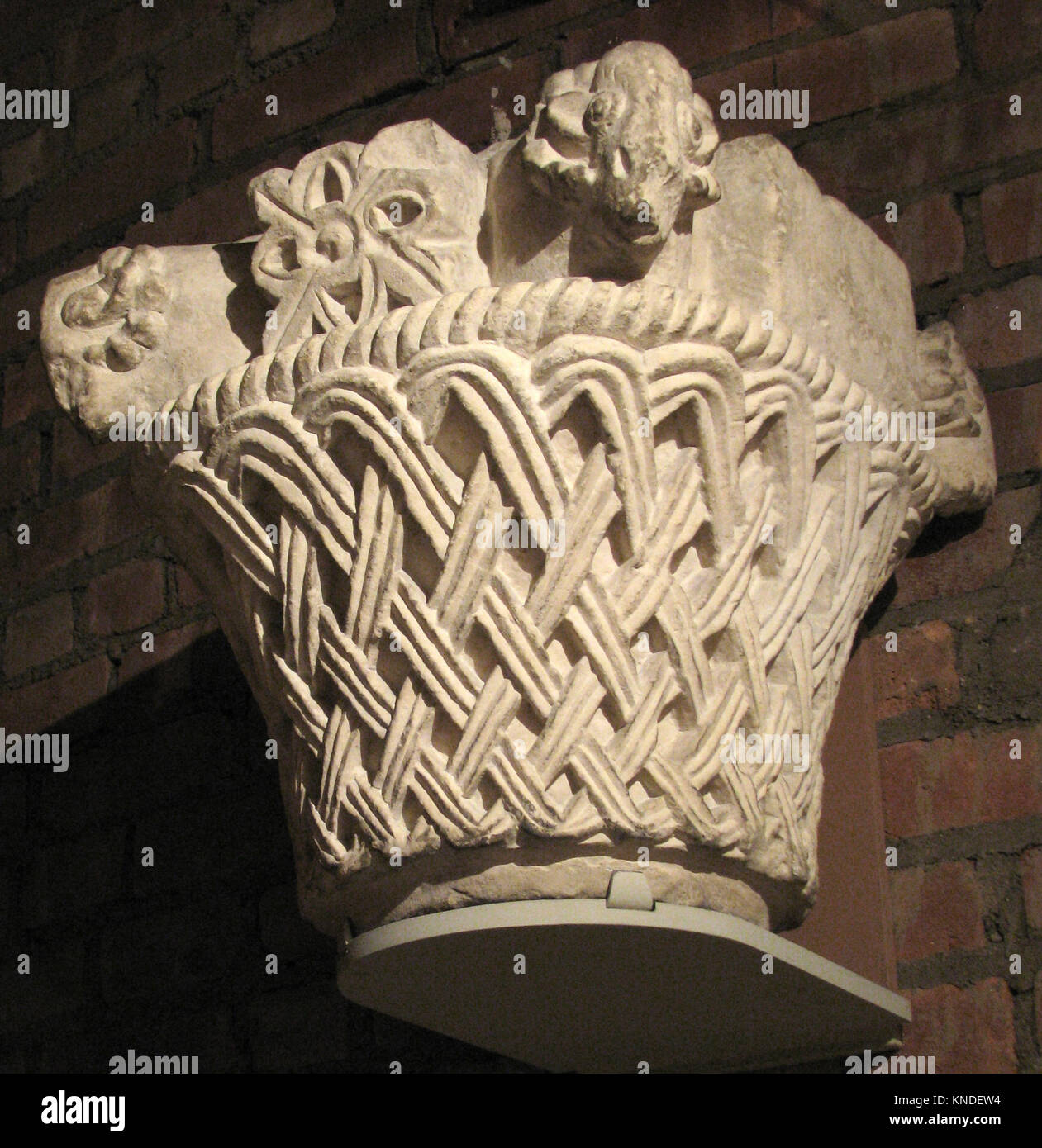 This architectural capital features a basket-weave pattern with rams ...