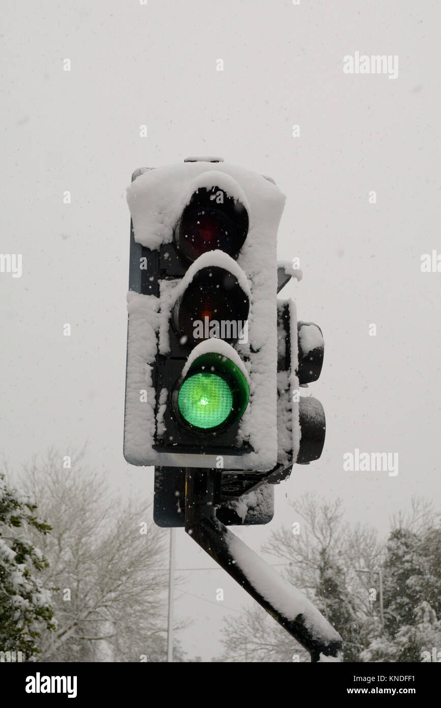 Traffic lights covered in snow with lights on green for go Stock Photo