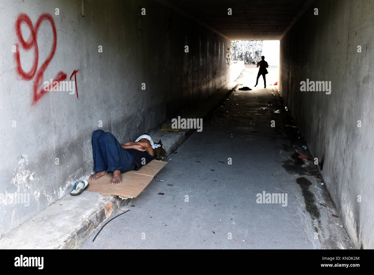 asian homeless man sleeping in a tunnel. living concept Stock Photo