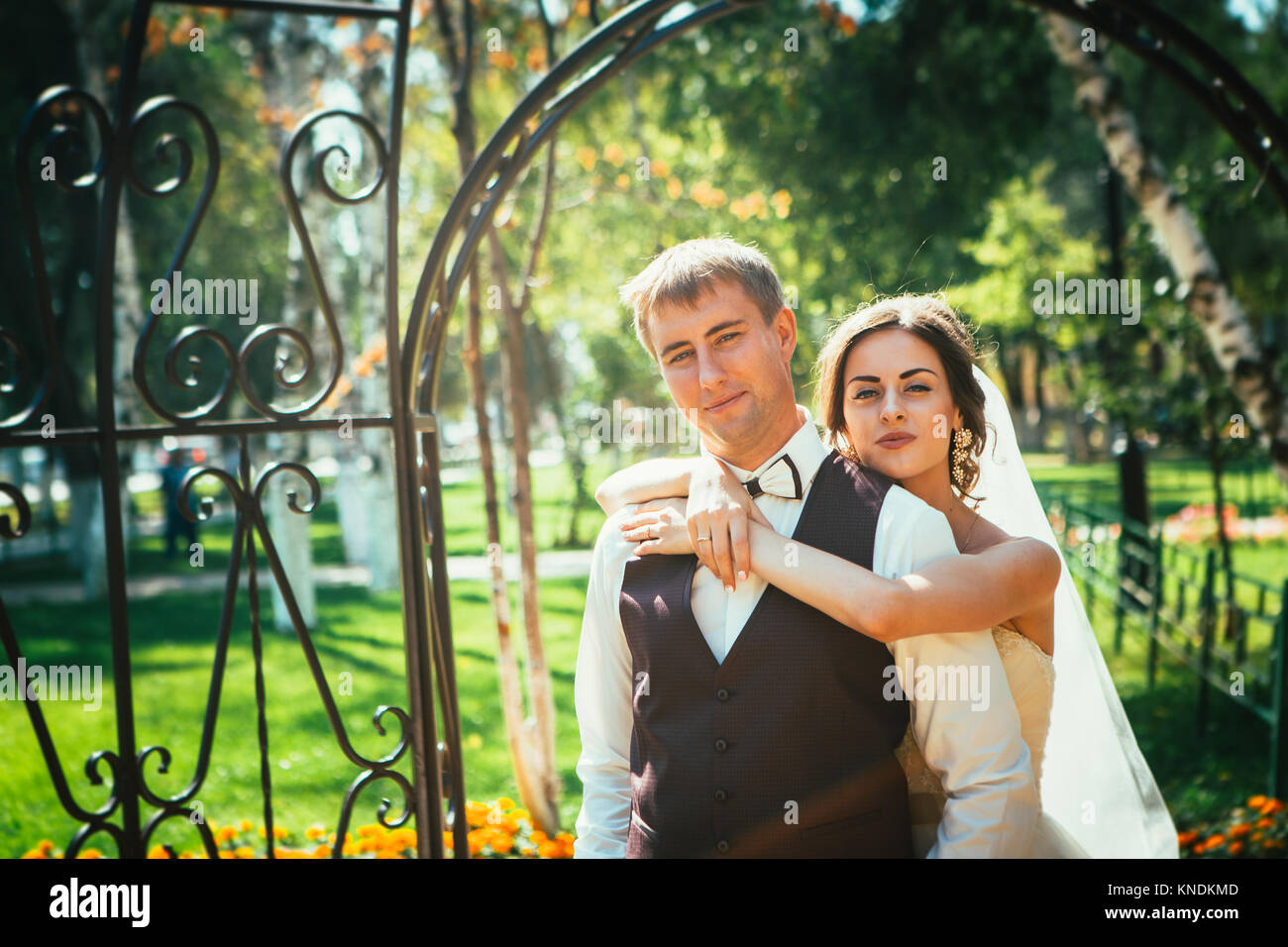 The bride and groom in the park arch Stock Photo - Alamy