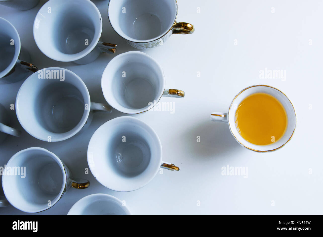 Enlighten others.A concept represented of coffee cups, one full of "ideas" and the other empty-master, mentor,give light, help others,  leadership Stock Photo