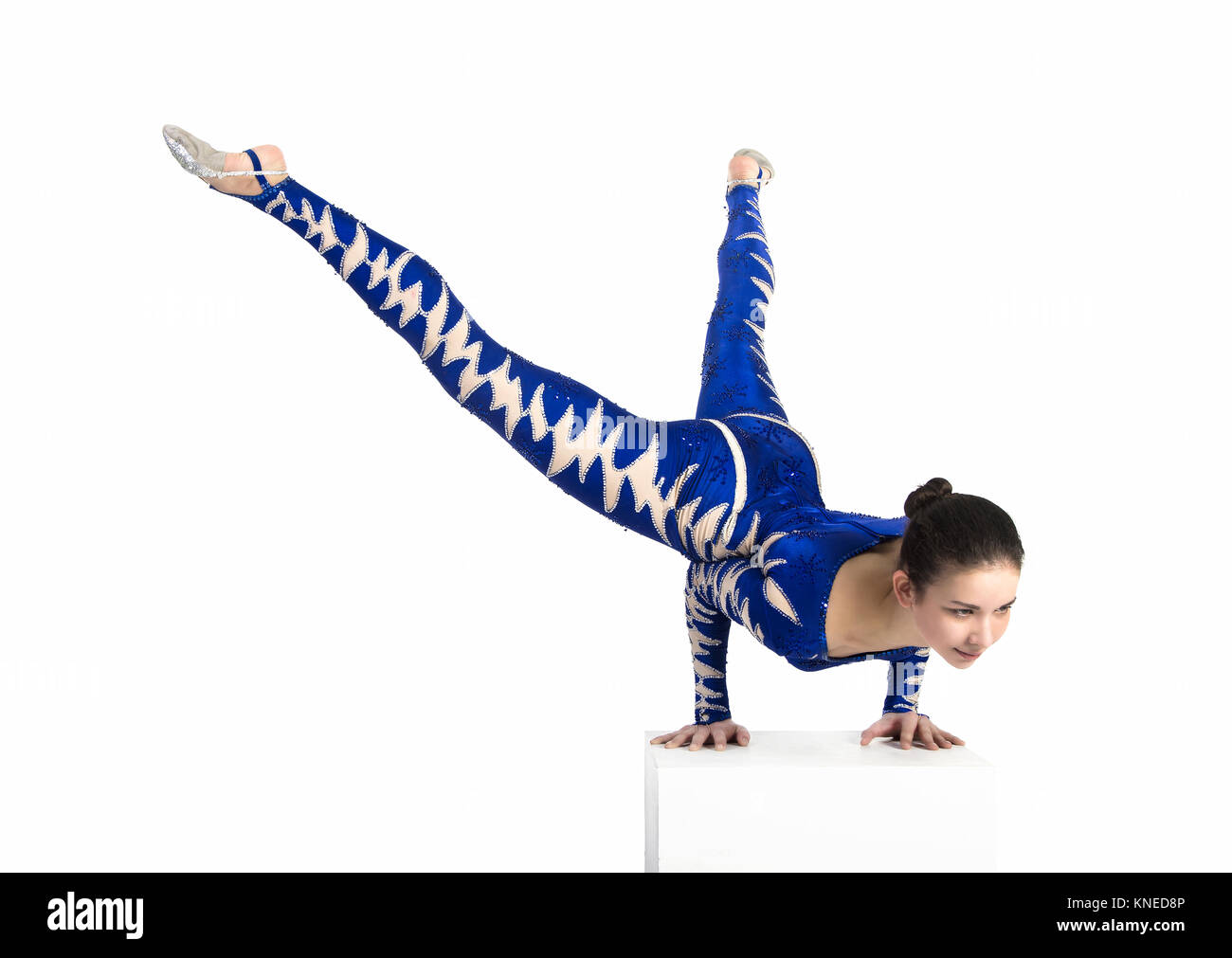 Acrobat does gymnastics, isolated image on a white background. A young circus artist in a blue suit , performs acrobatic elements. Stock Photo