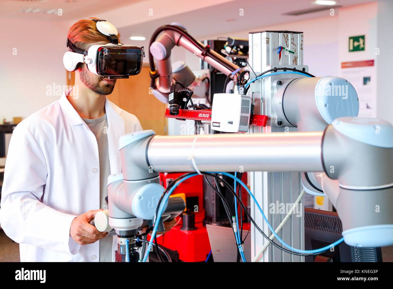 Robotic arm with artificial vision, Researcher with virtual reality glasses, VR, Humanoid robot for automotive assembly tasks in collaboration with Stock Photo
