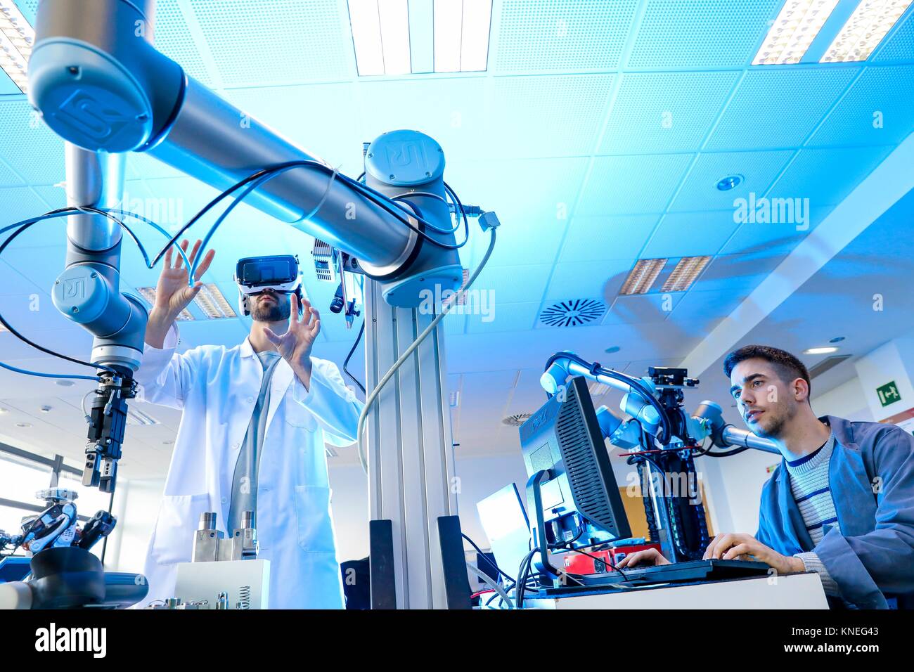 Robotic arm with artificial vision, Researcher with virtual reality glasses, VR, Humanoid robot for automotive assembly tasks in collaboration with Stock Photo