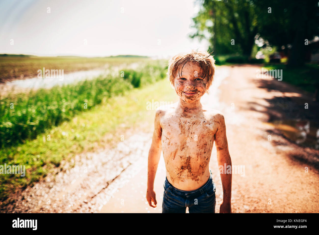 Portrait of boy standing outside covered in dirt Stock Photo - Alamy