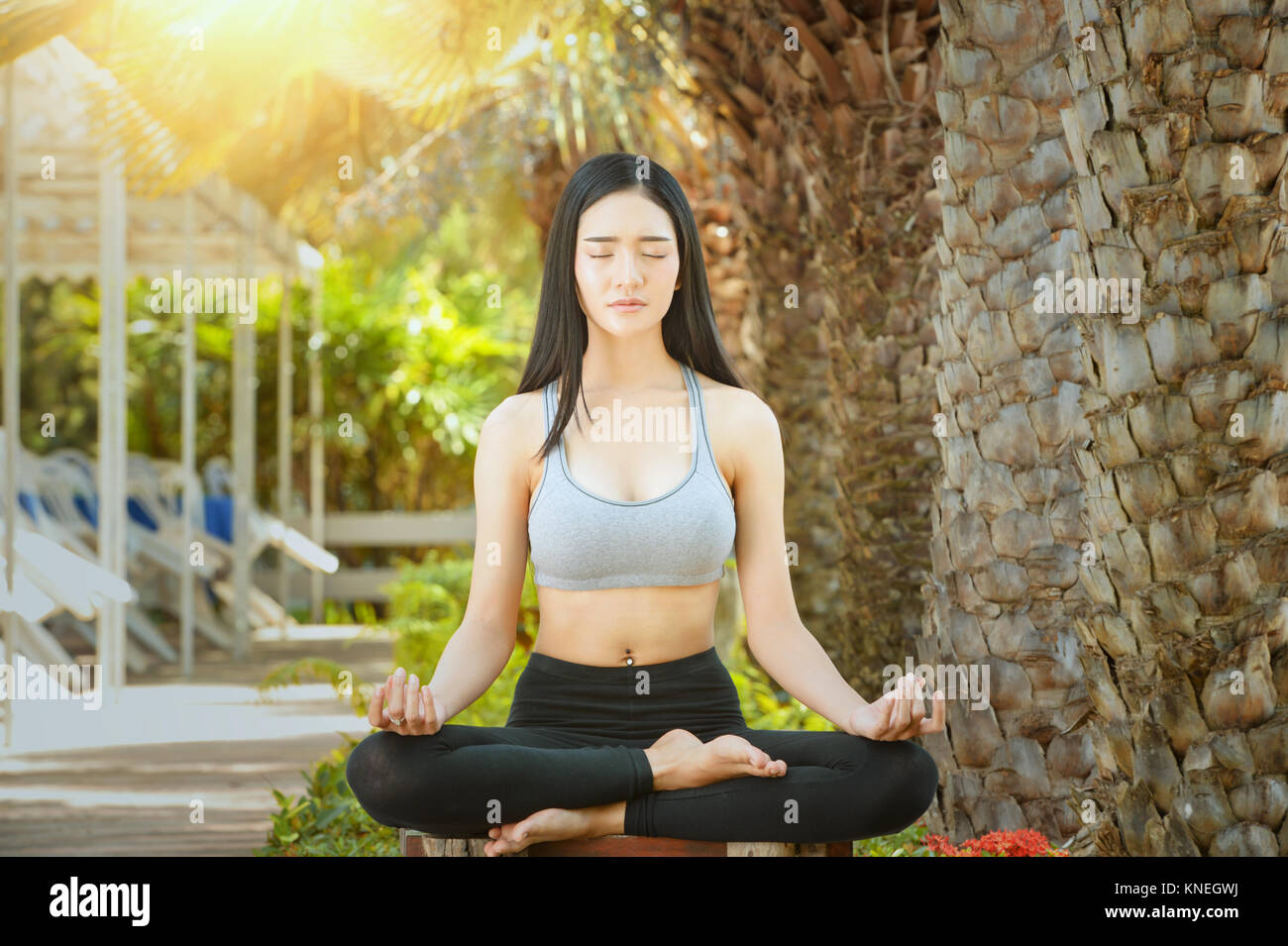 Woman sitting in a park doing yoga Stock Photo