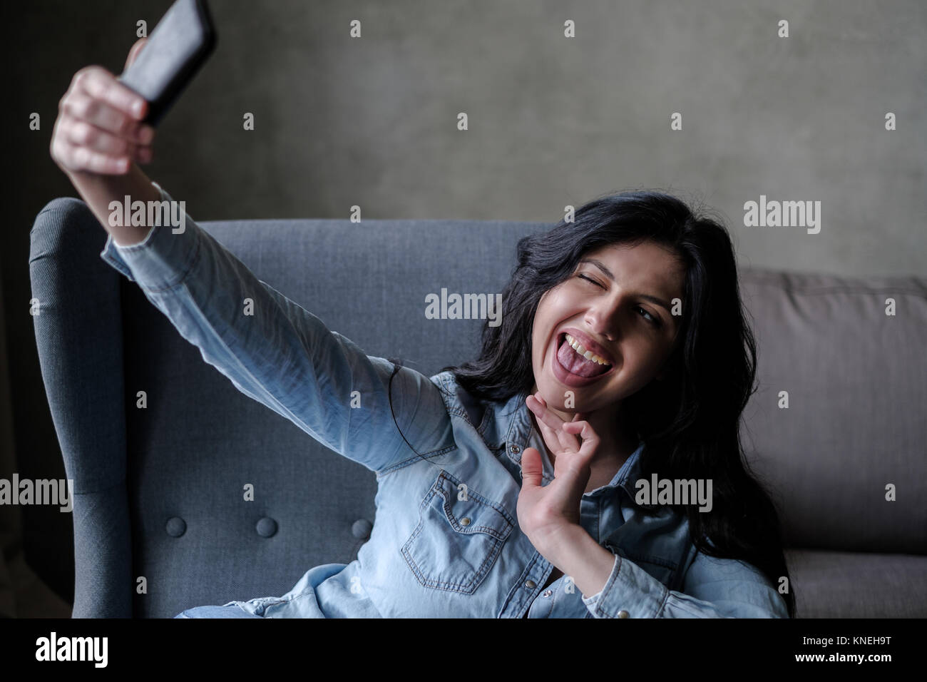 Woman sitting in a chair taking a selfie Stock Photo