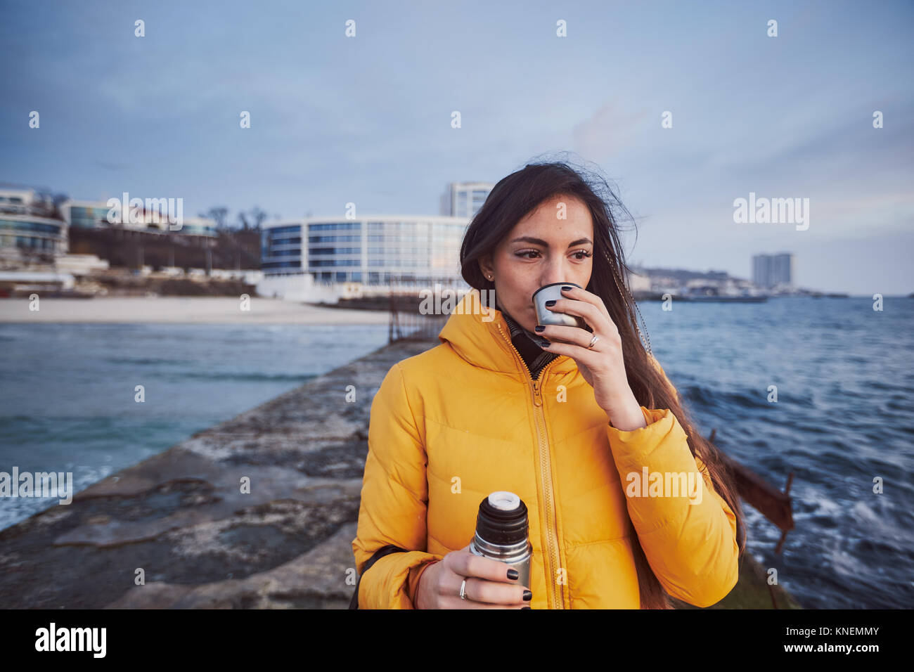 Woman on pier drinking from flask, Odessa, Odessa Oblast, Ukraine, Europe Stock Photo