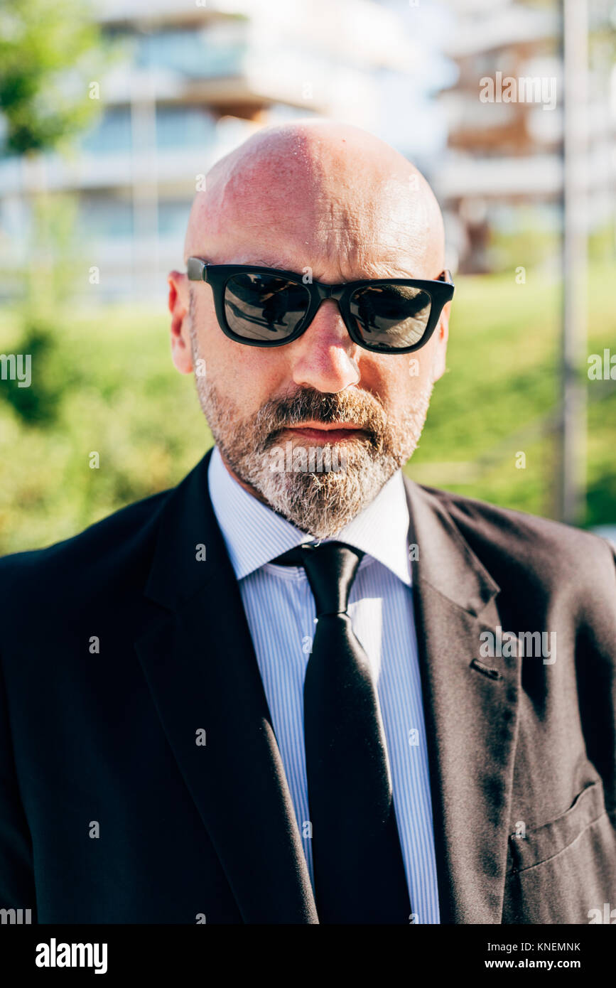 Portrait of mature businessman outdoors, wearing sunglasses Stock Photo
