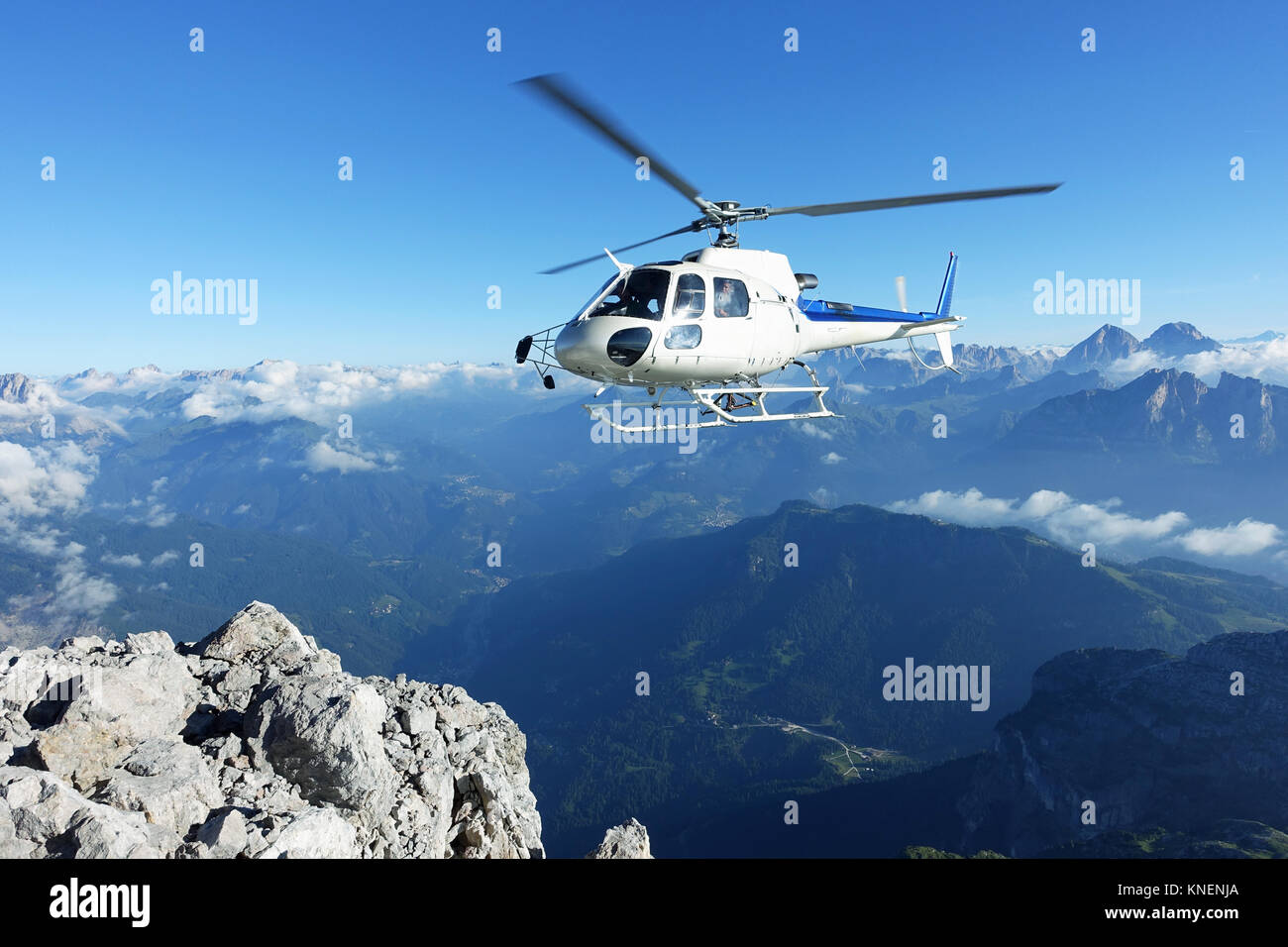 Helicopter approaching BASE jumper exit at the cliff edge Stock Photo