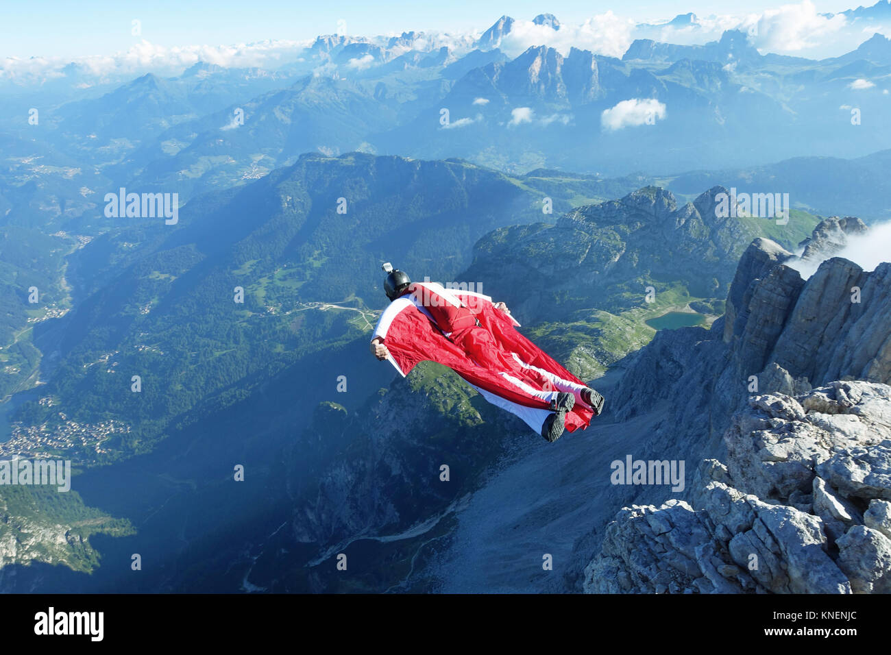 Male wingsuit BASE jumper taking off from cliff edge Stock Photo
