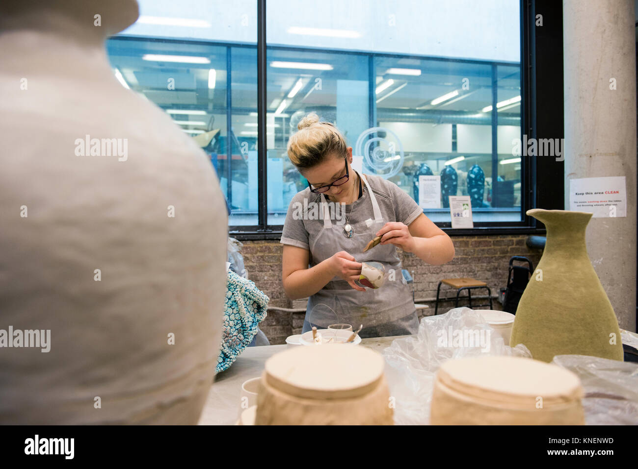 Woman in art studio glazing pottery Stock Photo - Alamy