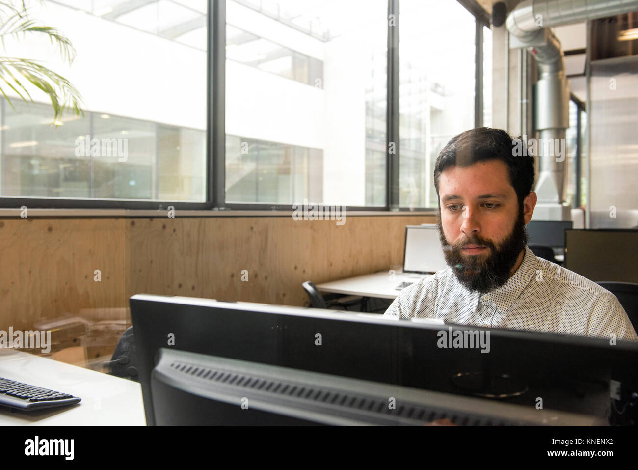 Man in office using desktop computer Stock Photo