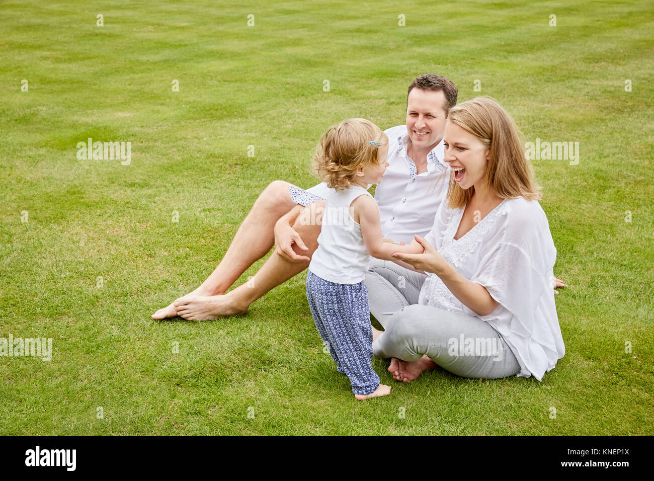 Couple with daughter on green lawn Stock Photo