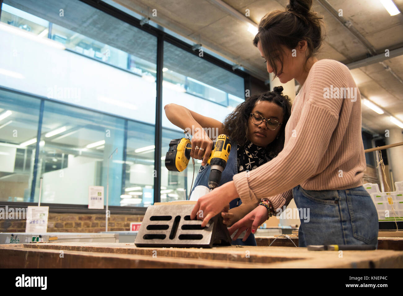 Students in art studio assembling object using cordless screwdriver ...