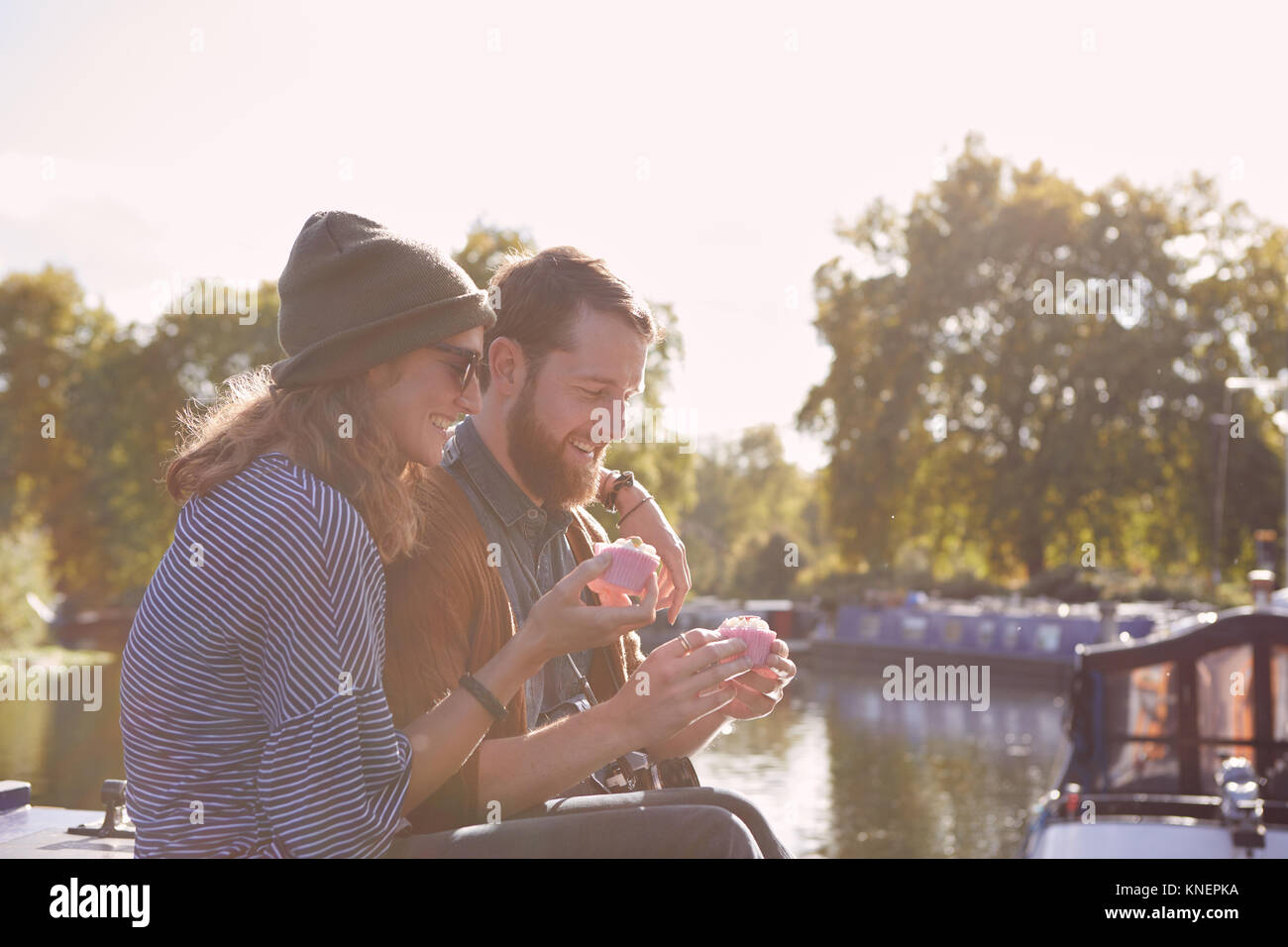 Couple eating cupcakes on canal boat Stock Photo