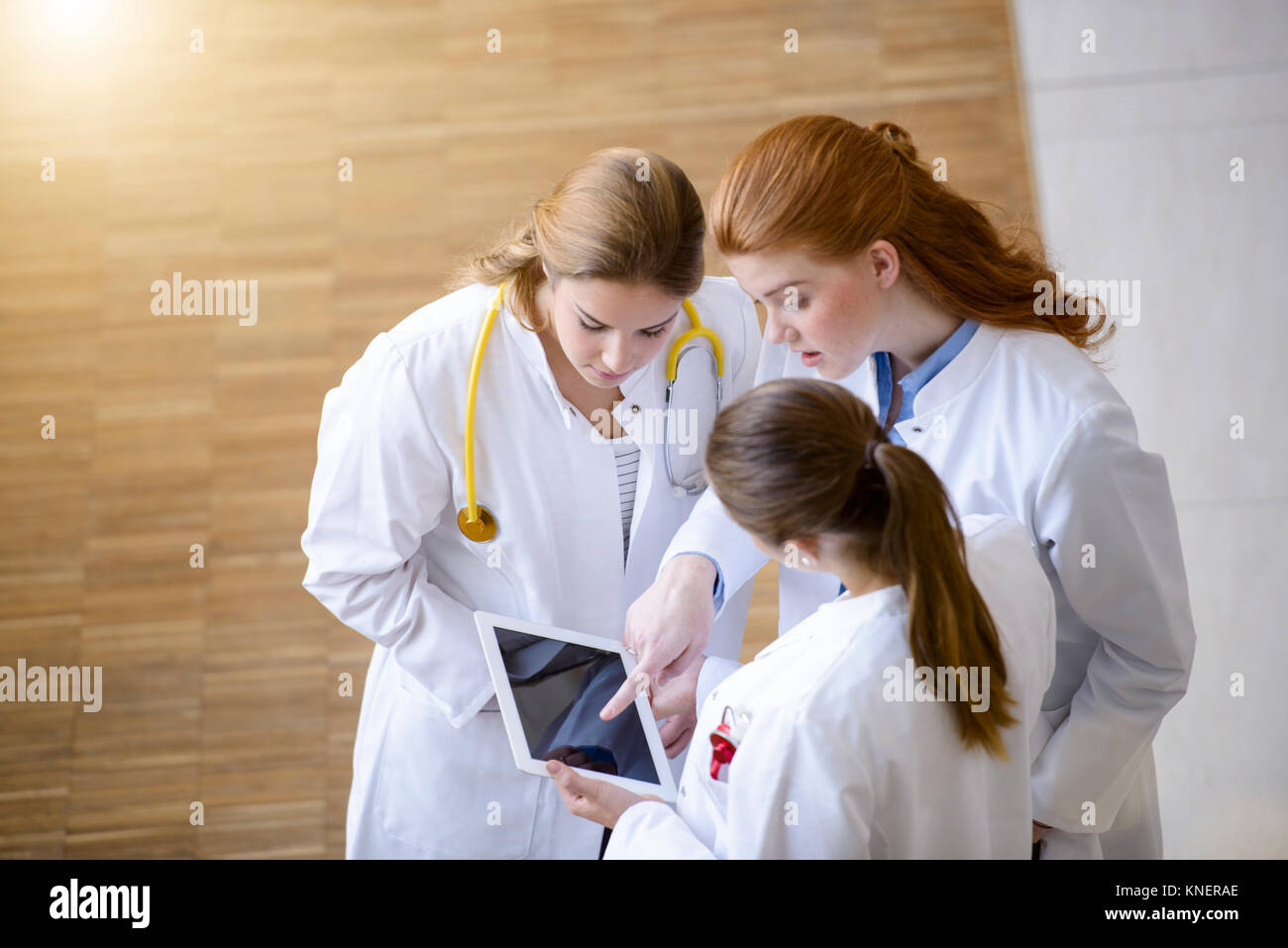 Three female doctors looking at digital tablet Stock Photo