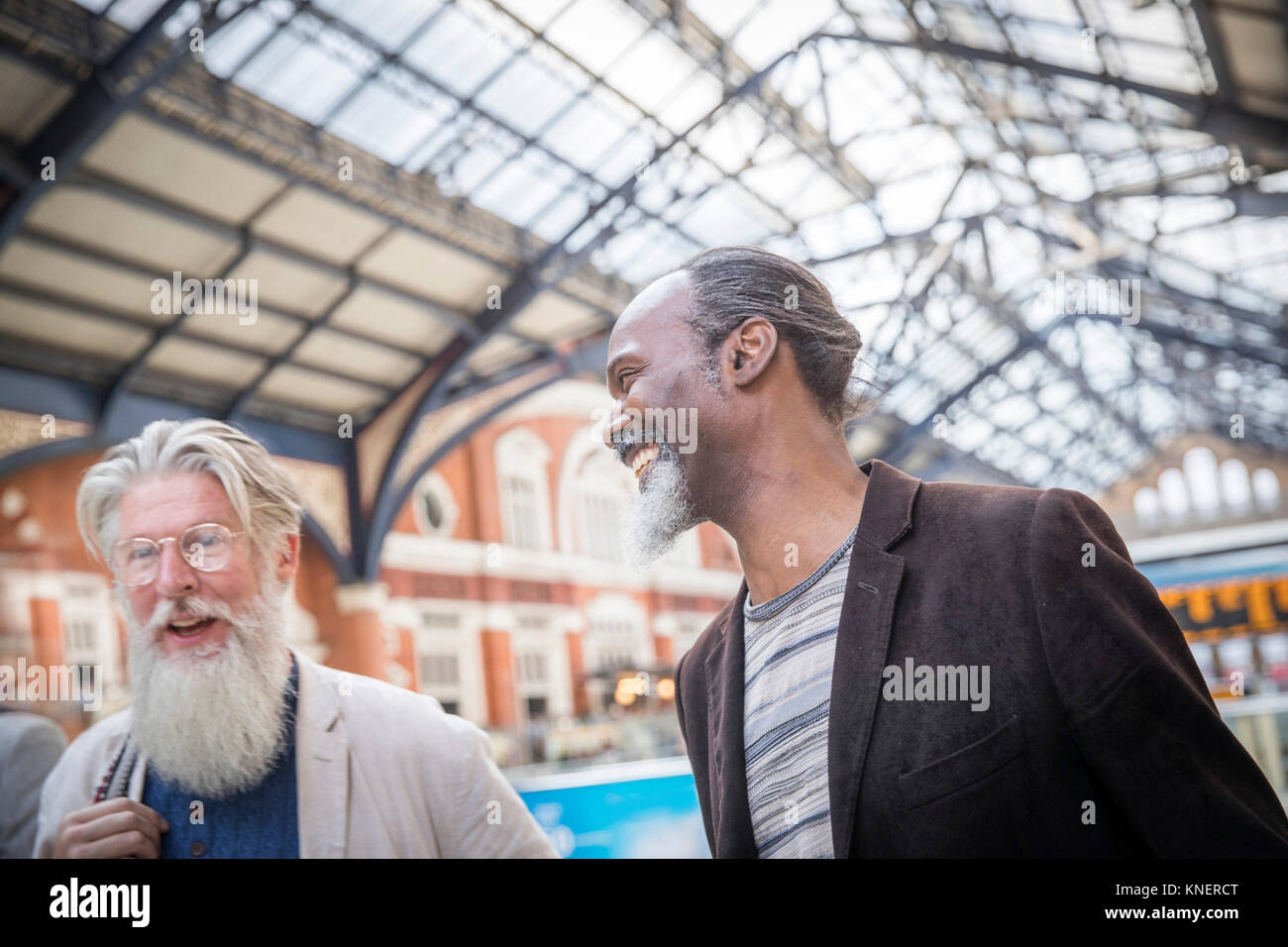 Two mature men at train station, walking together Stock Photo