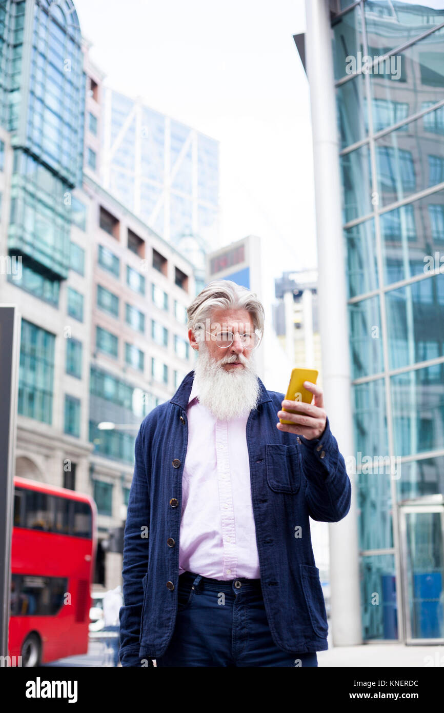 Mature man outdoors, using smartphone Stock Photo