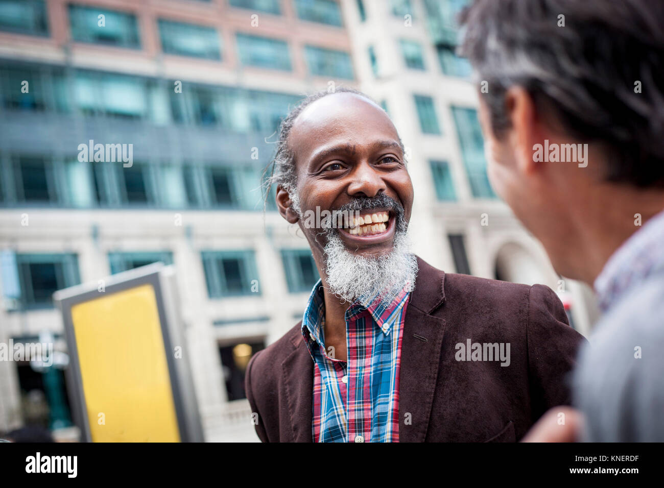 Two mature men outdoors, laughing together Stock Photo