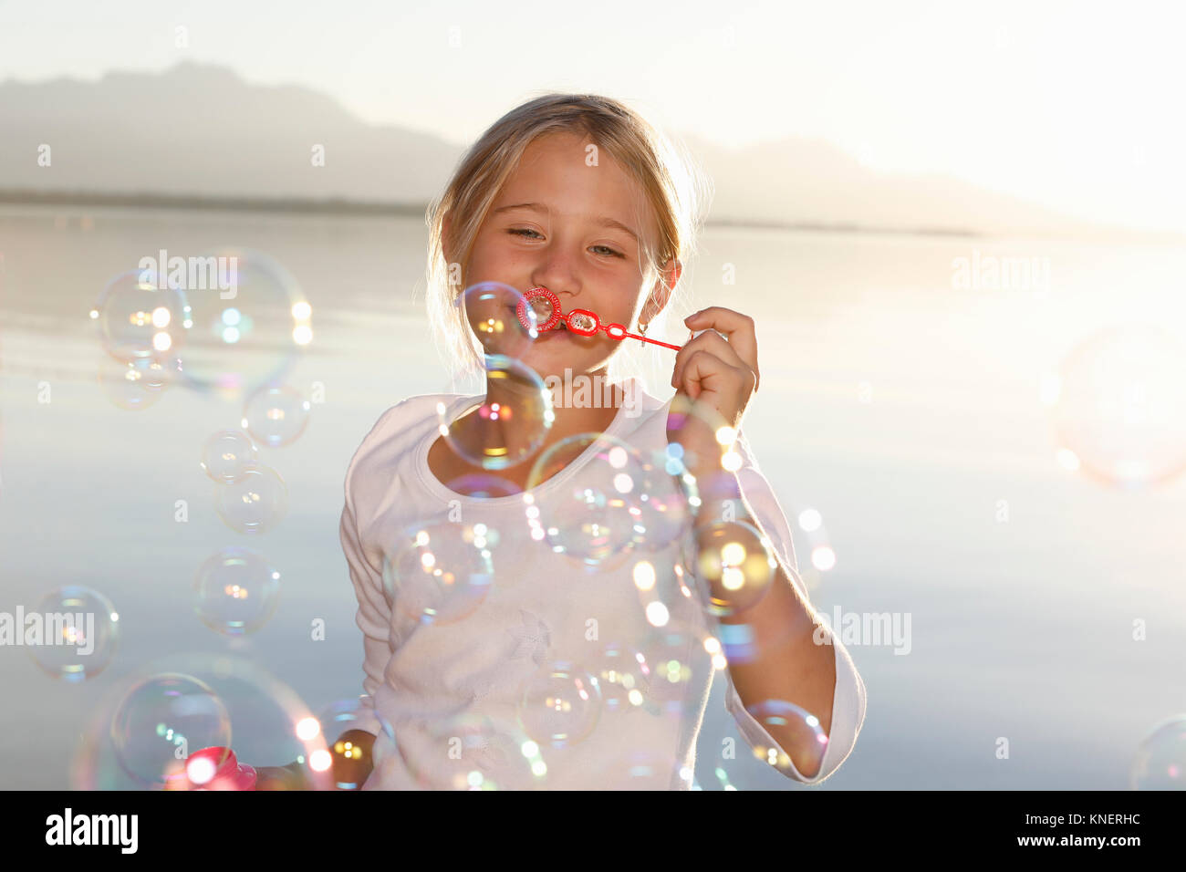 Young girl, outdoors, blowing bubbles Stock Photo