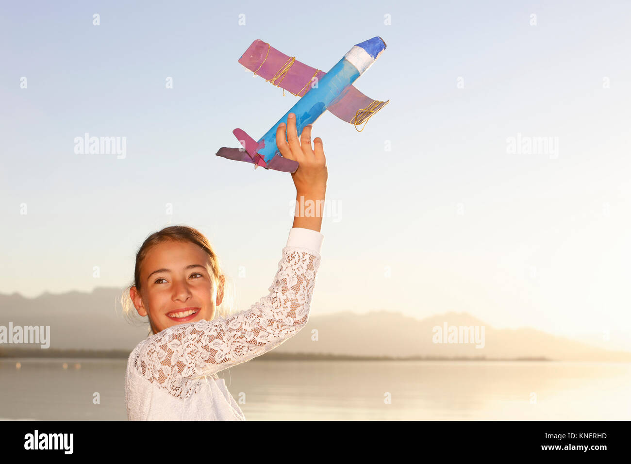 Young girl, outdoors, playing with toy aeroplane Stock Photo