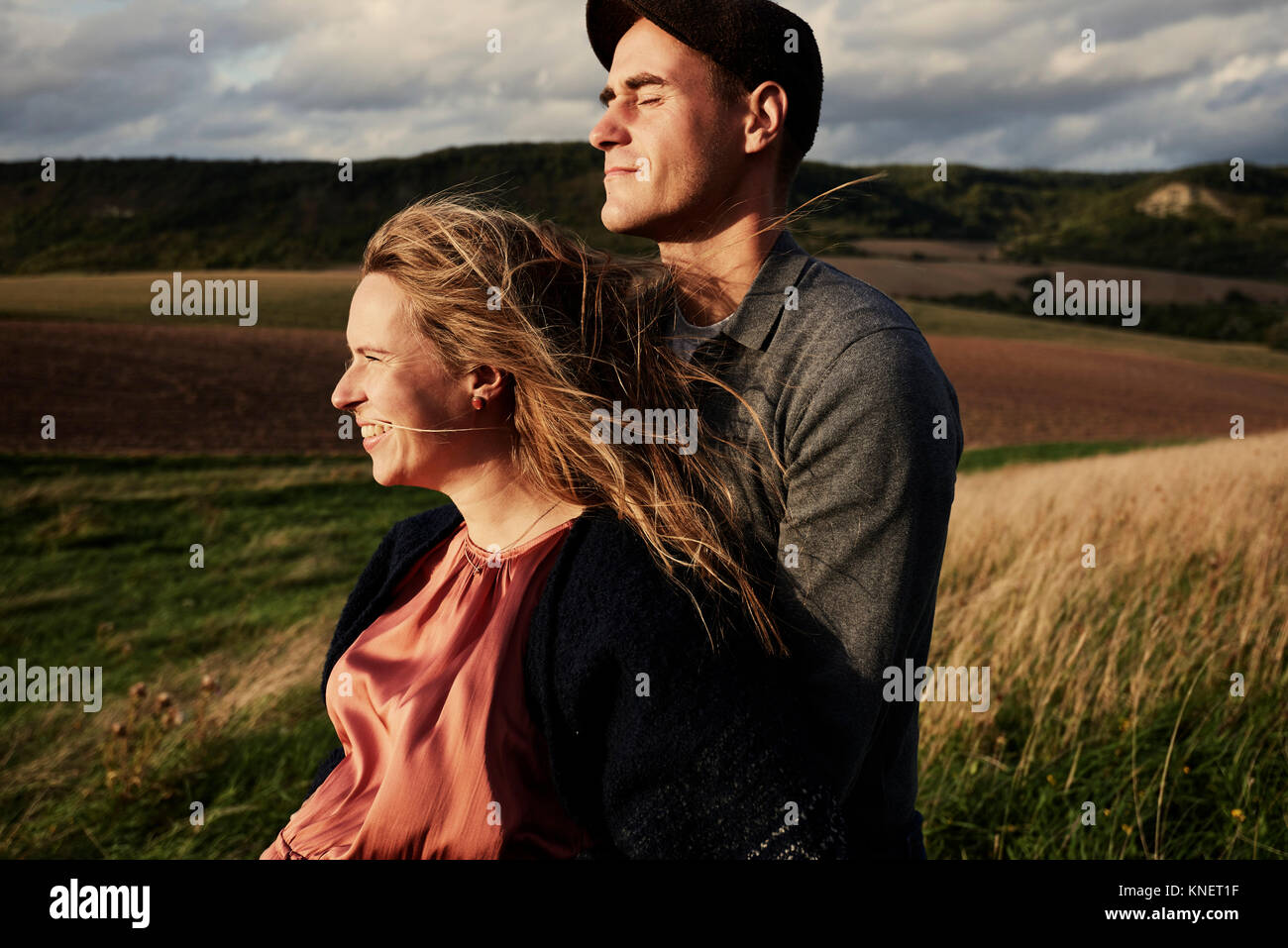 Pregnant mid adult couple on windy hillside Stock Photo