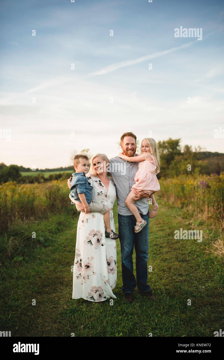 Smiling parents holding children in rural area Stock Photo
