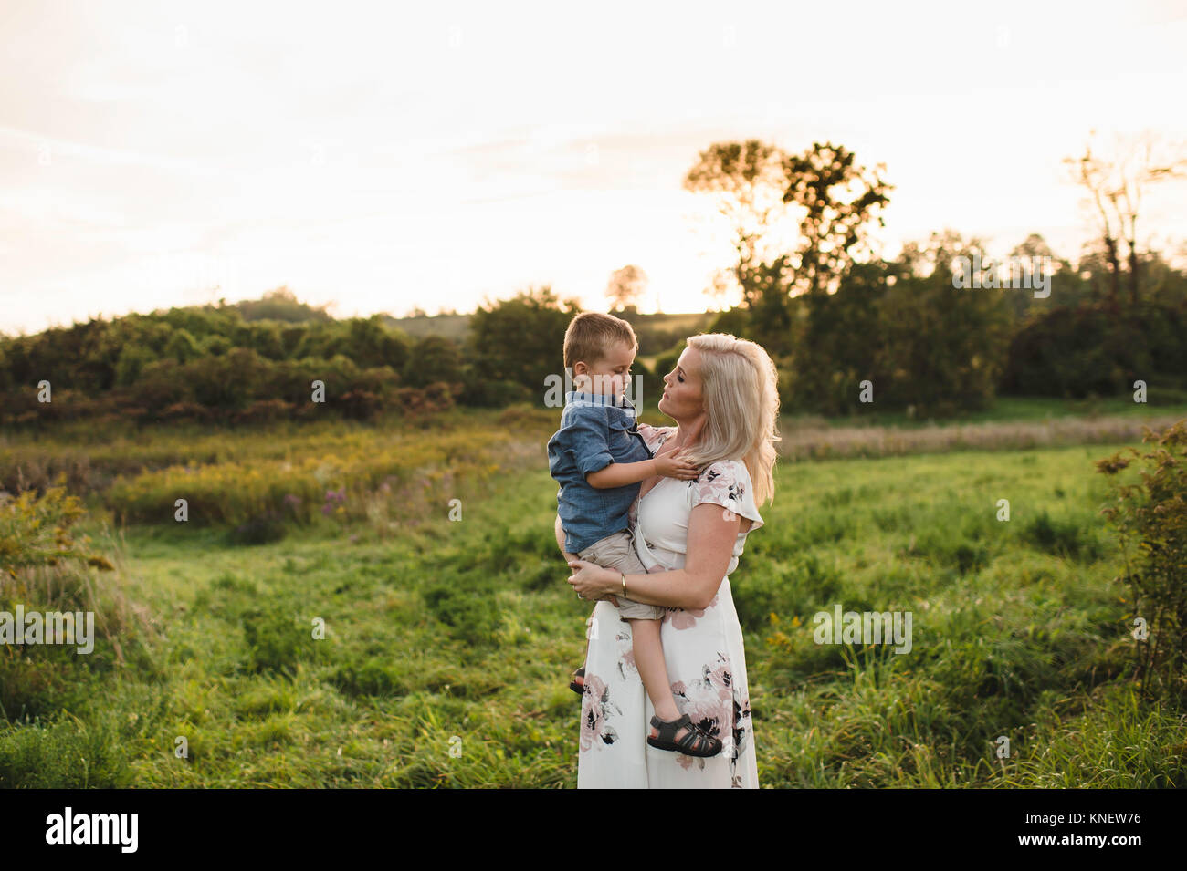 Mother holding son in rural area Stock Photo