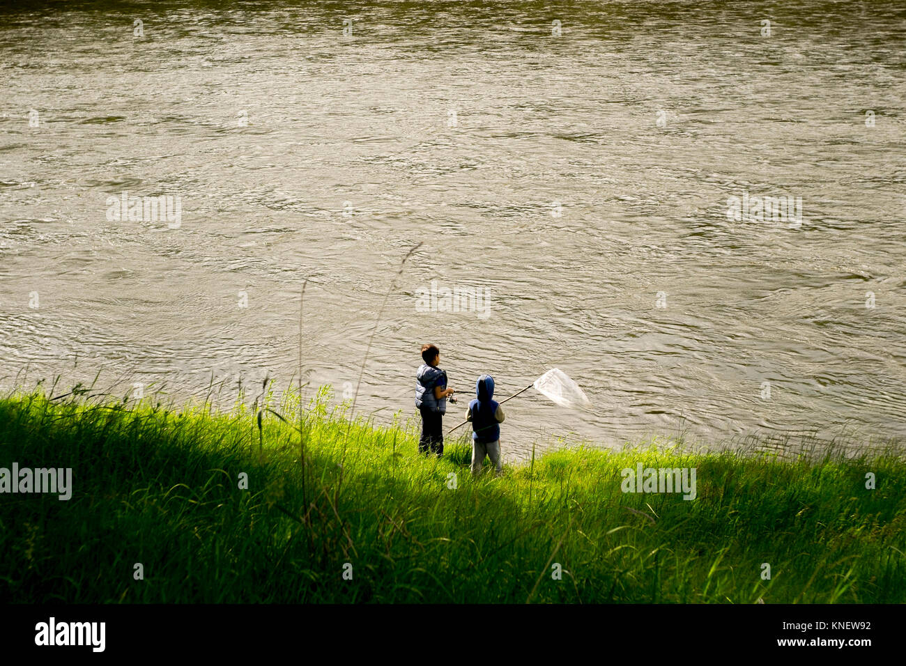 Two boys beside water, holding fishing net, elevated view, Ural, Chelyabinsk, Russia, Europe Stock Photo