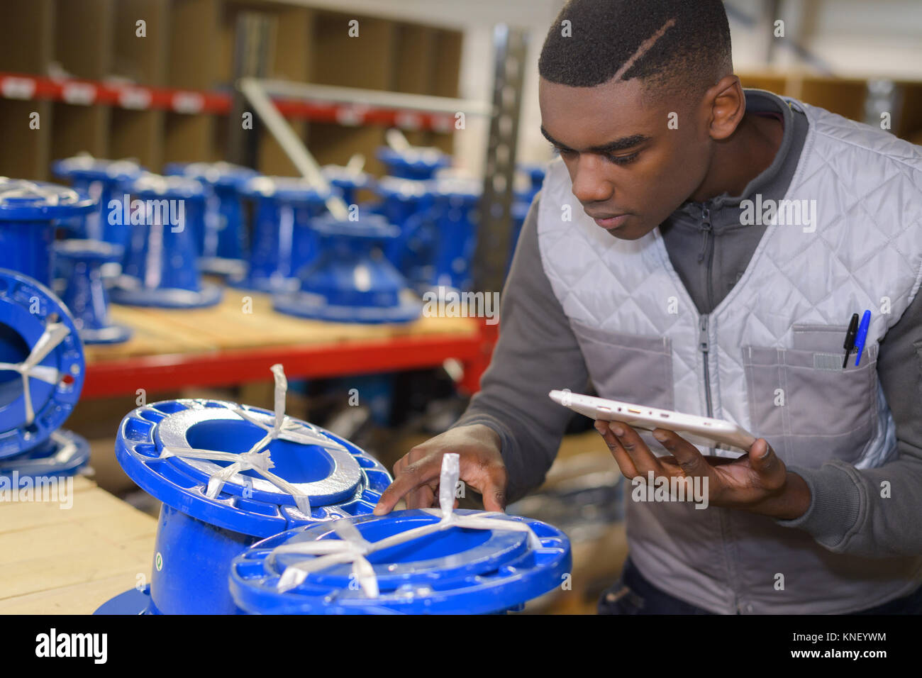 man in a warehouse is checking inventory levels of goods Stock Photo ...