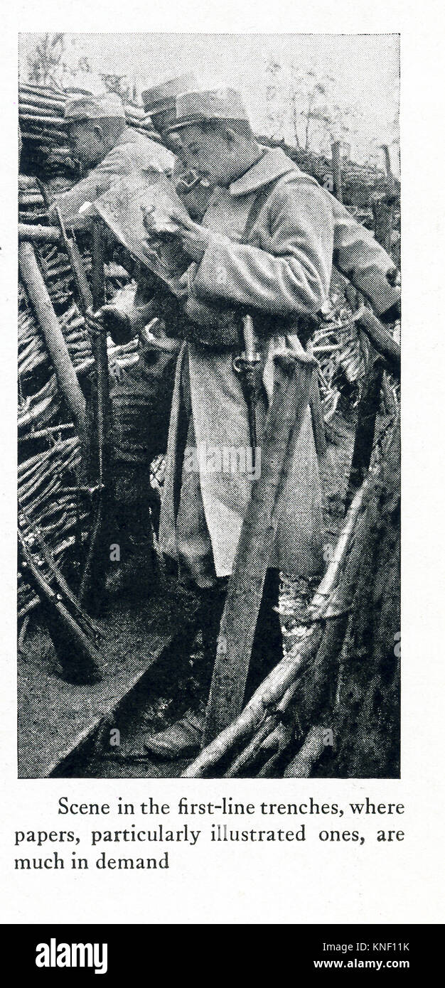 The caption for this photo that dates to between 1914 and 1917 (time of the First World War) reads: Scene in the first-line trenches, where papers, particularly illustrated ones, are much in demand. Stock Photo