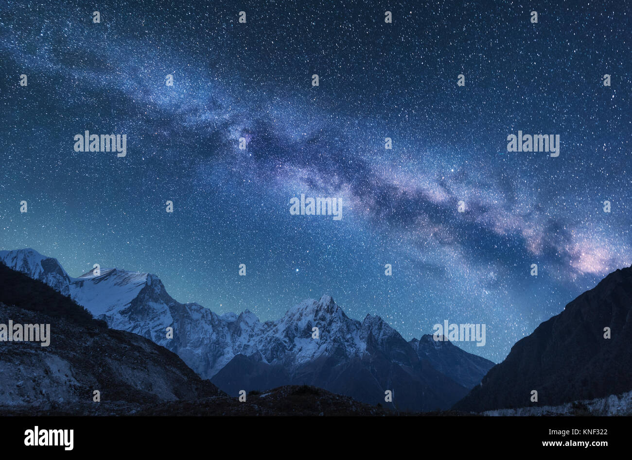 Milky Way and mountains. Amazing scene with himalayan mountains and starry sky at night in Nepal. Rocks with snowy peak and sky with stars. Beautiful  Stock Photo