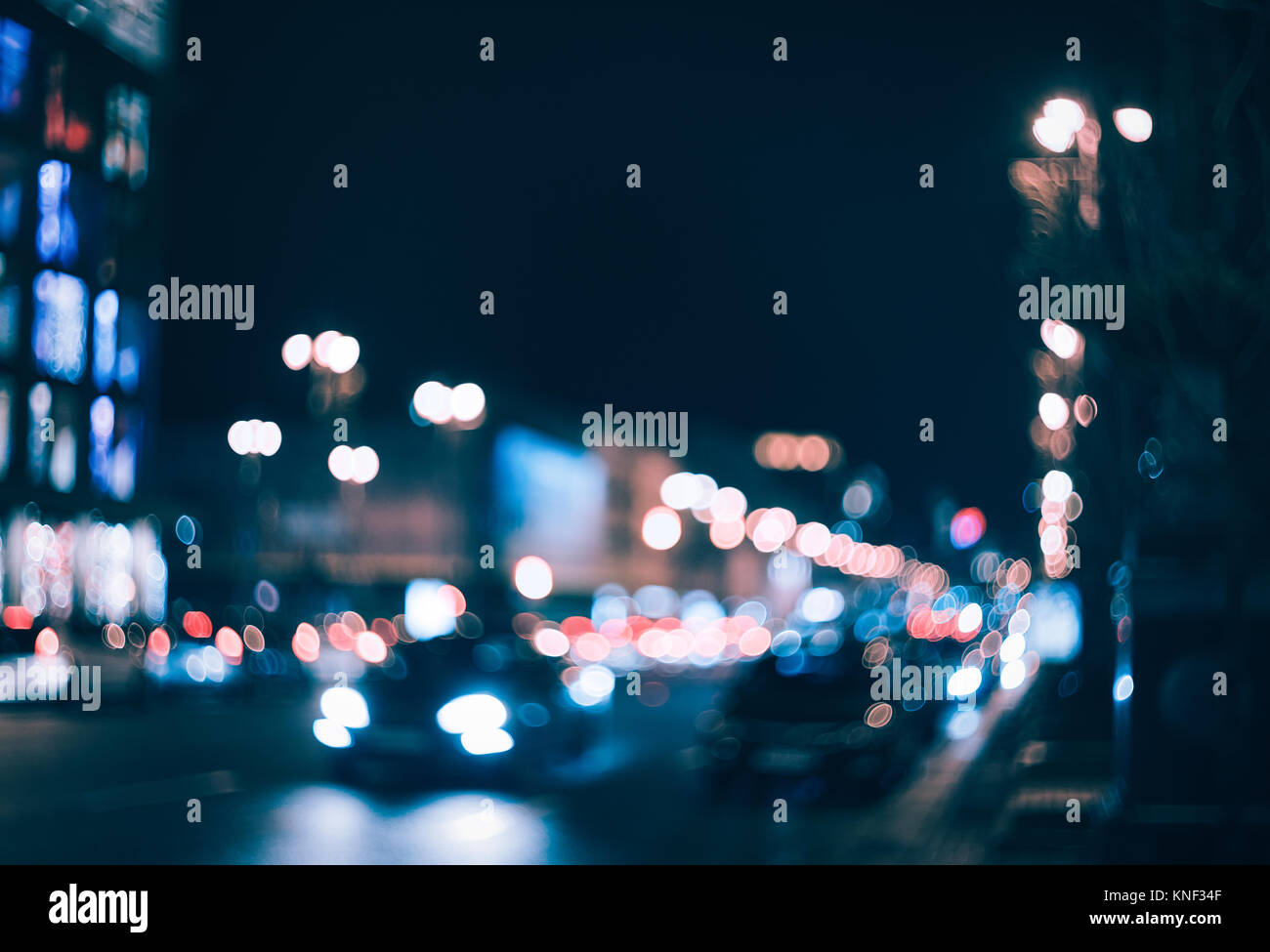 Blurred city at night. Bokeh. Beautiful abstract background with defocused buildings, cars, city lights, people. Colorful bokeh background with urban  Stock Photo