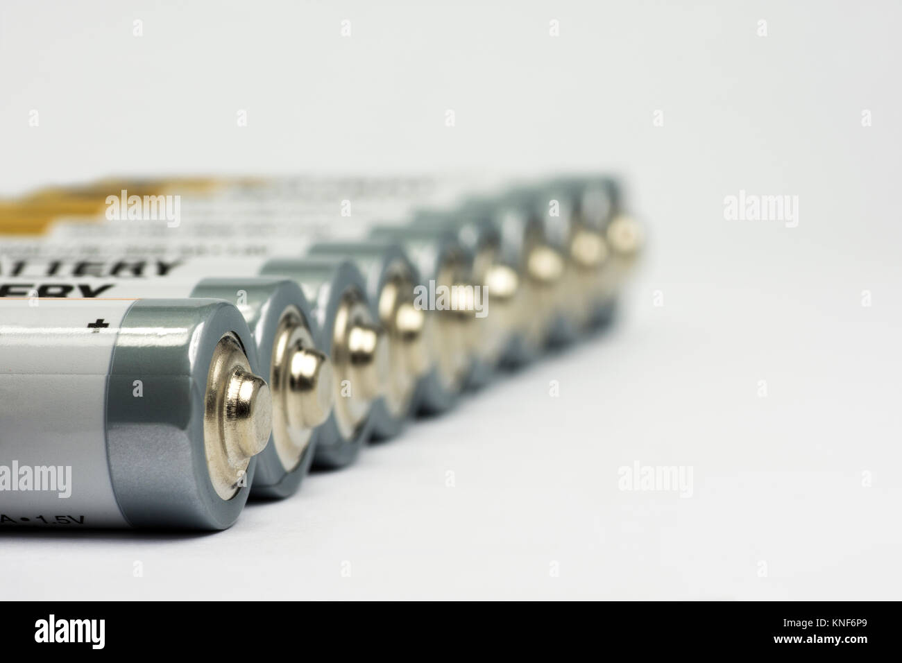 Row lying AA battery on white background with blurred background Stock Photo