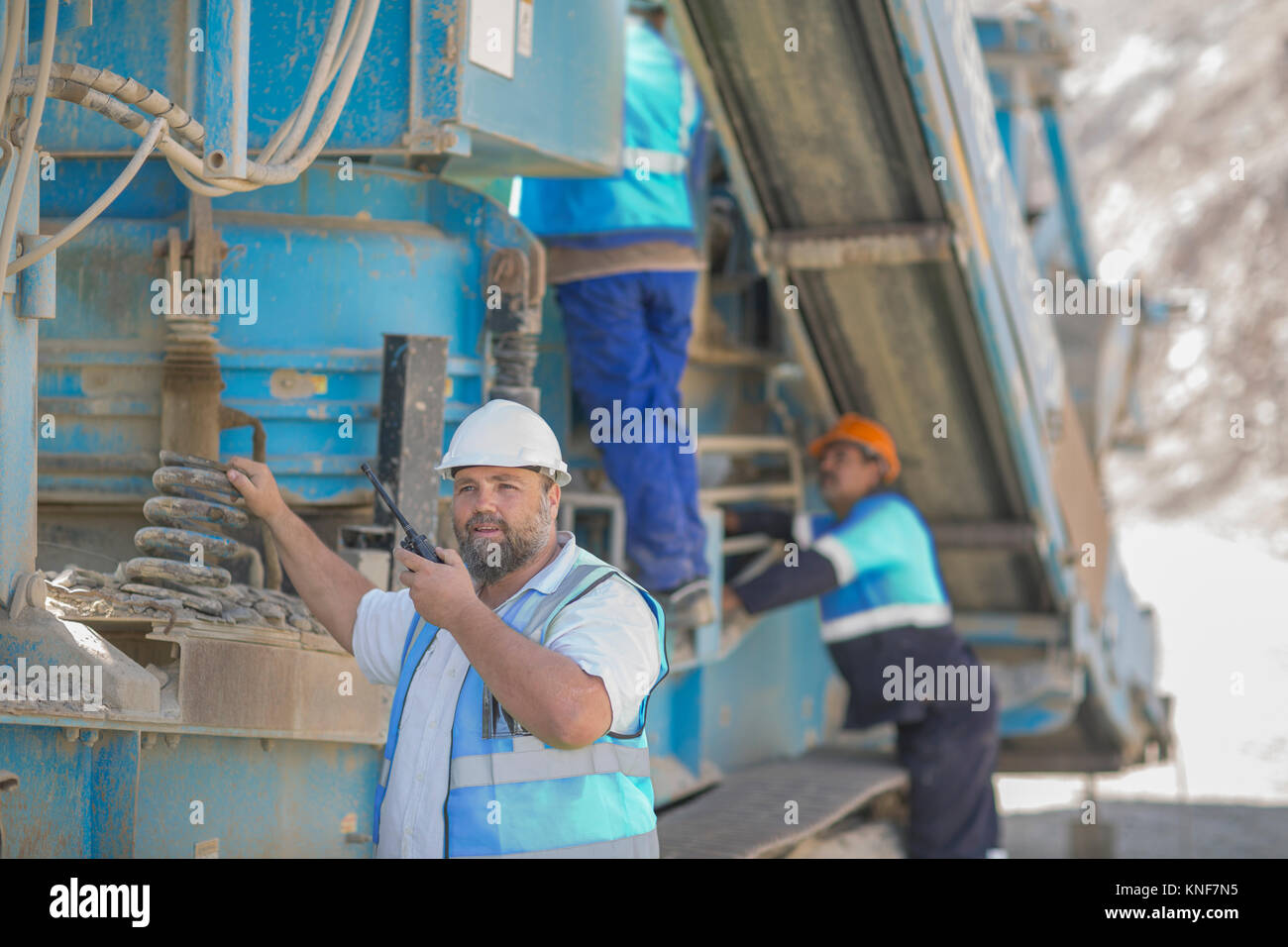 Quarry workers tending to heavy machinery Stock Photo Alamy