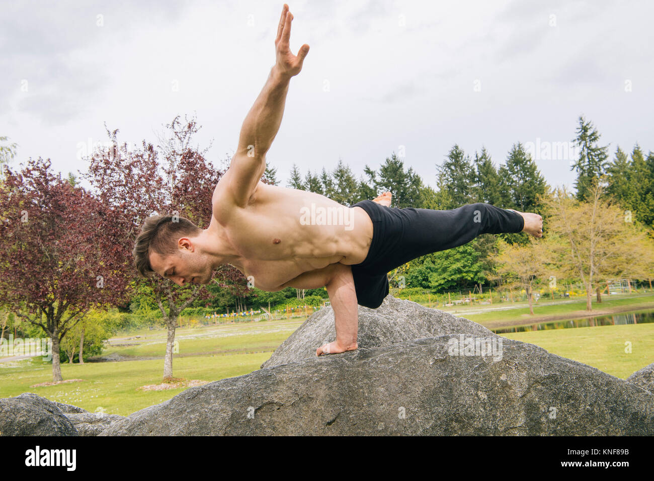 Man balancing on rock with one hand, Seattle, Washington, United States, North America Stock Photo