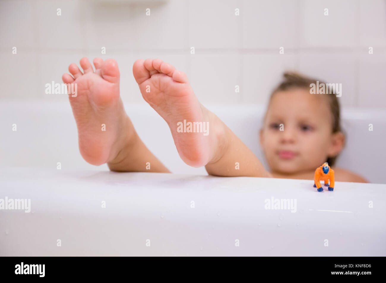 Girl with feet up relaxing in bath Stock Photo