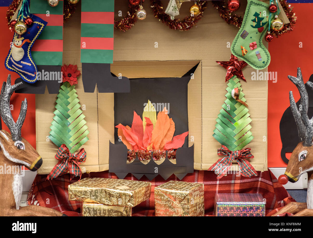 A handmade Christmas fireplace display made from cardboard in a library , Northwich, Cheshire UK Stock Photo