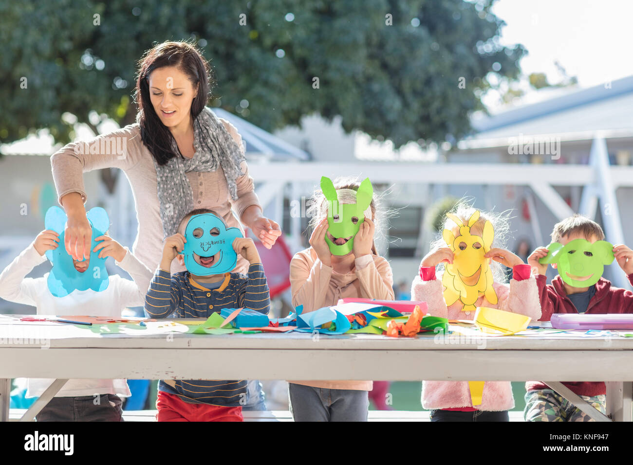Mid adult woman helping children with crafting activity, children ...
