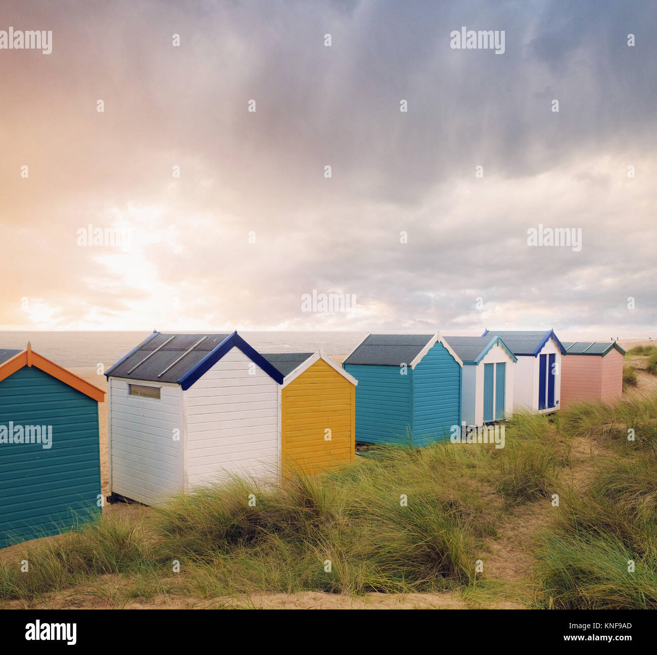 Row of colourful beach huts and storm clouds over sea, Southwold, Suffolk, England Stock Photo