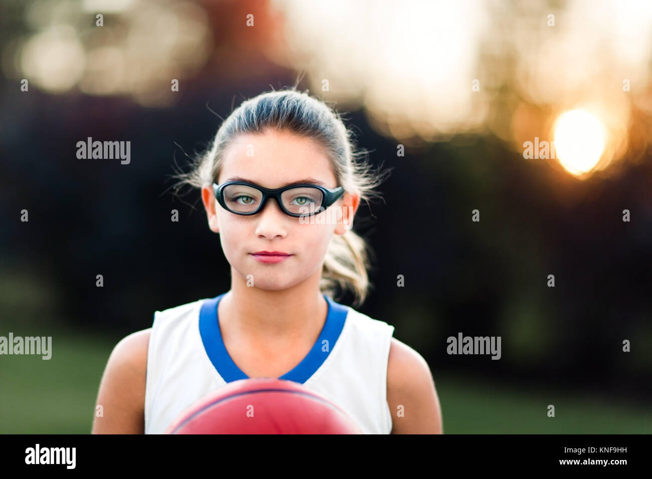 Portrait of girl wearing sports goggles holding basketball Stock Photo