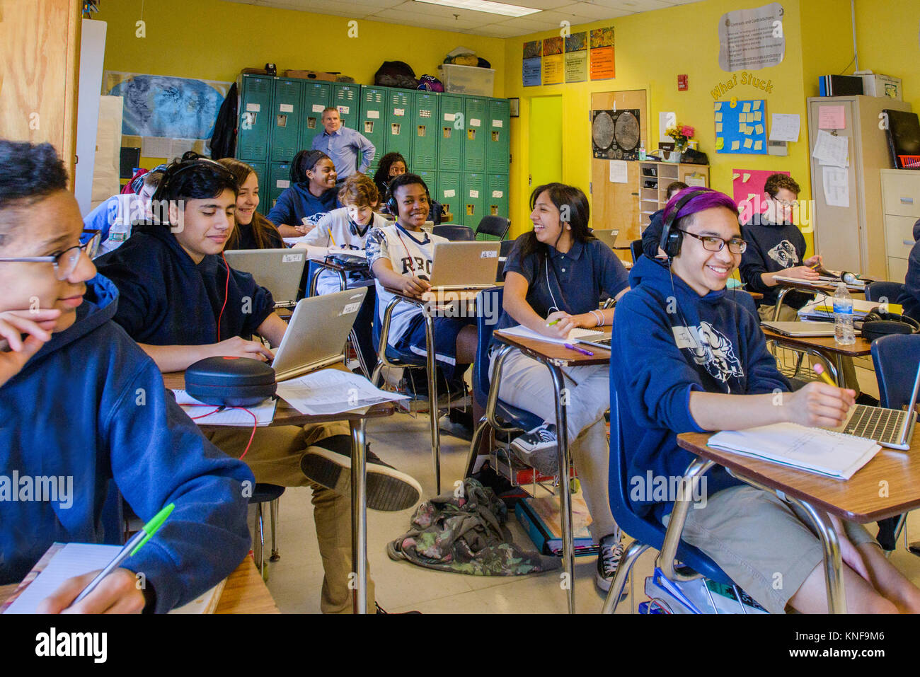 Class of teenage boys and girls doing schoolwork at classroom desks Stock Photo