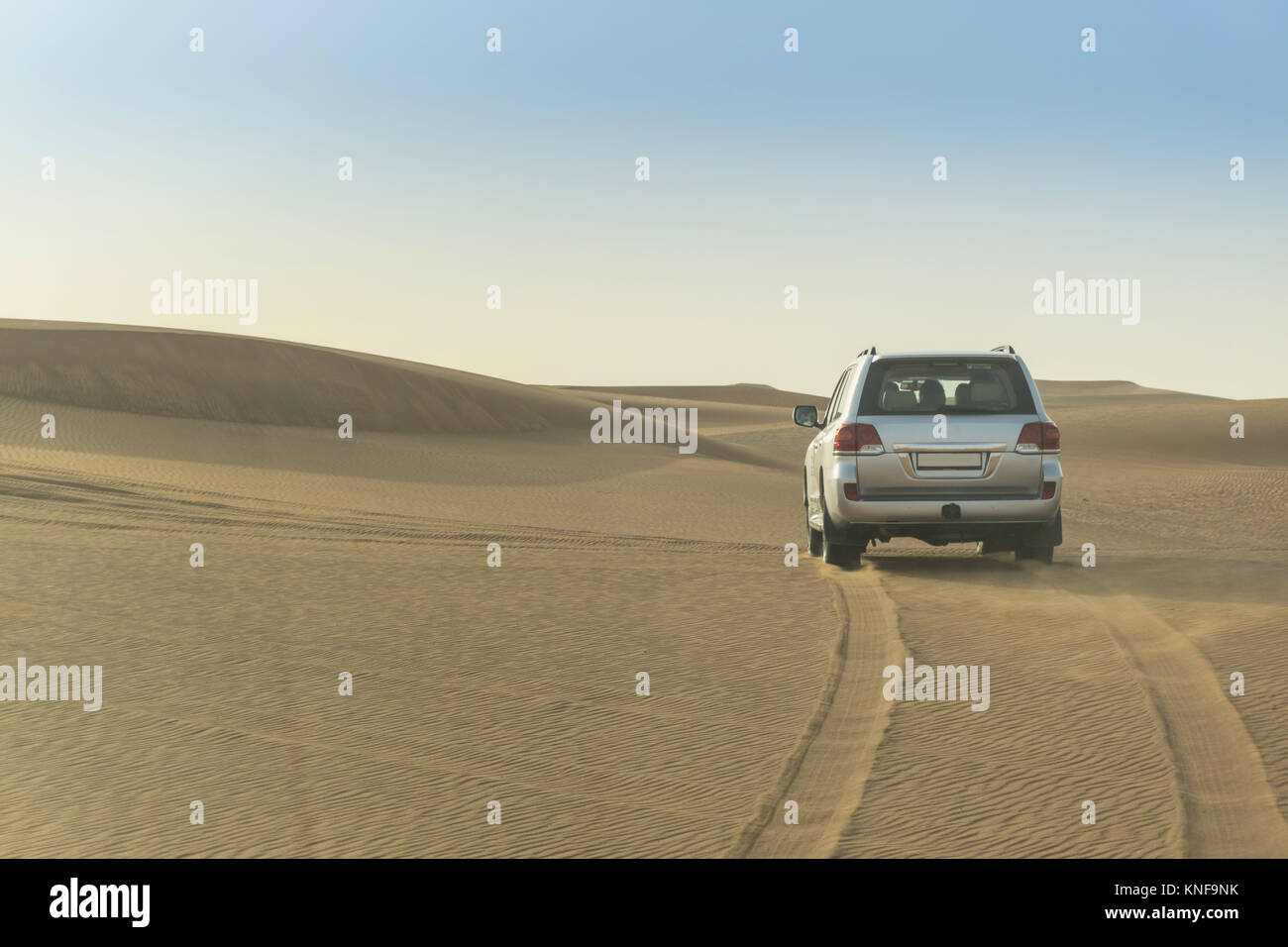 Off road vehicle driving over desert dunes, Dubai, United Arab Emirates Stock Photo