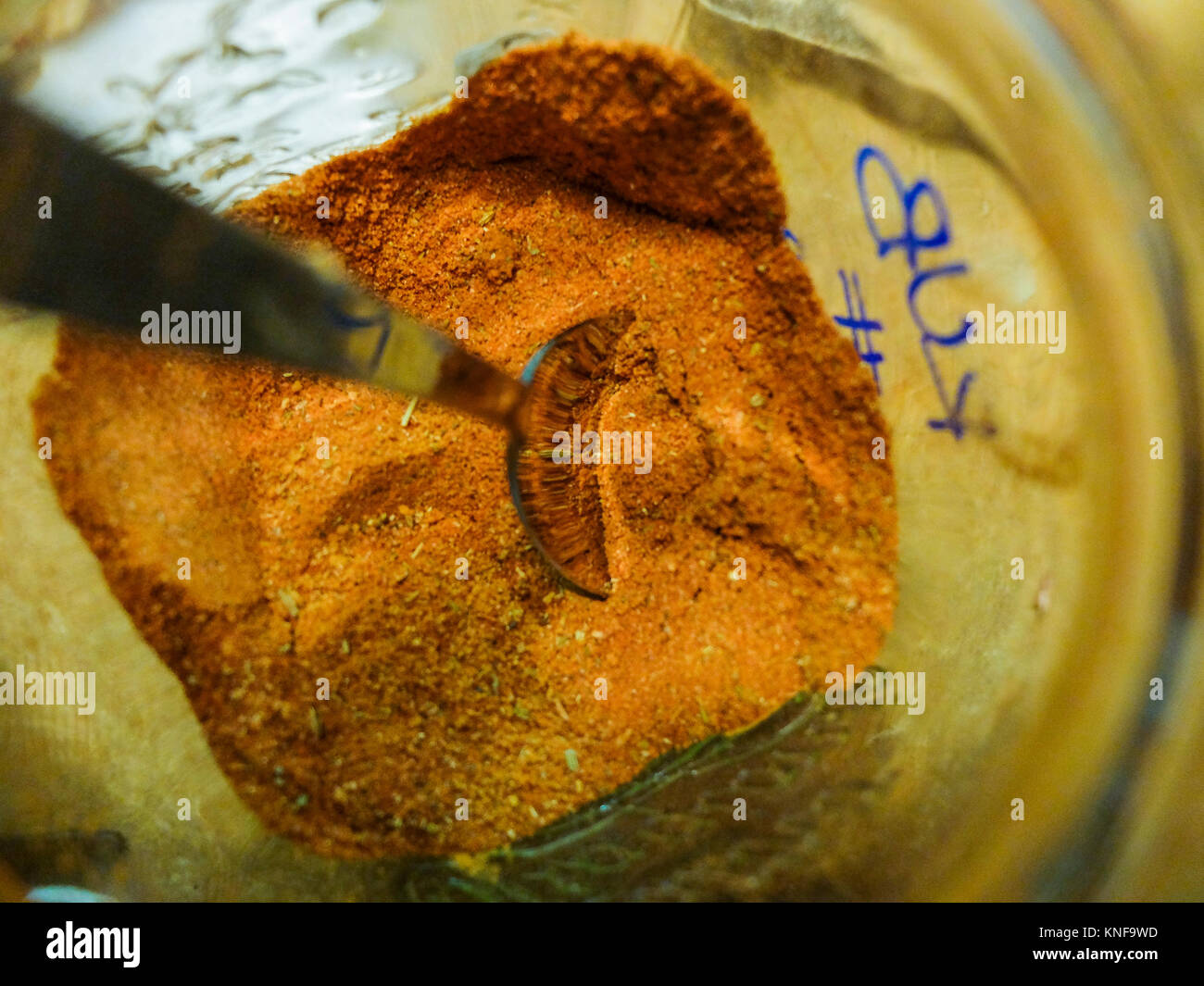 Jar with ready mix rub containing paprika and other spices with a spoon slipped Stock Photo