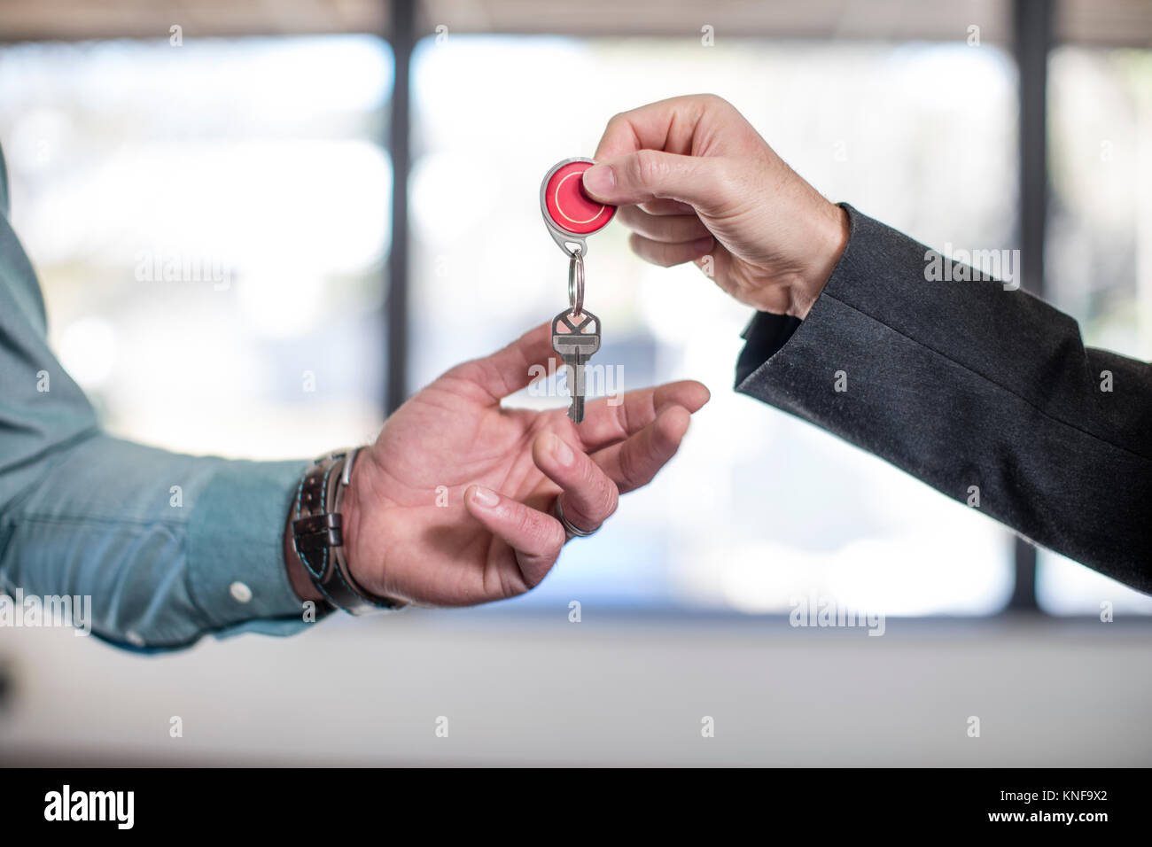 Estate agent handing keys to homebuyer, close-up Stock Photo